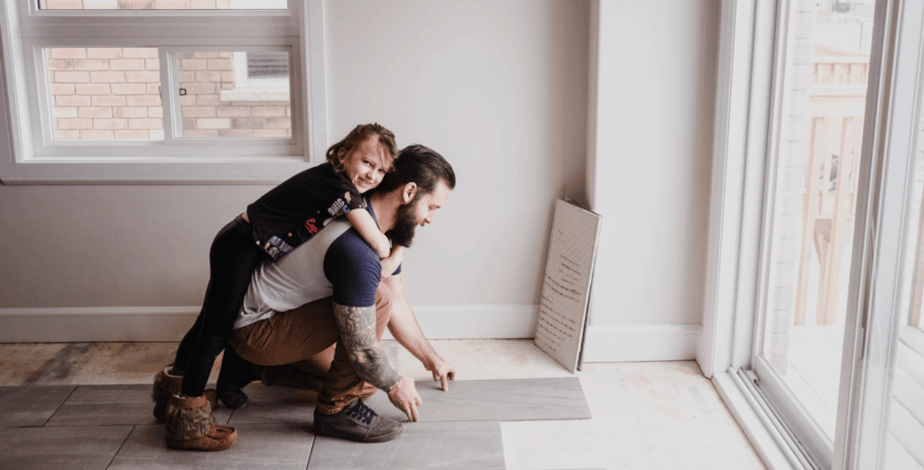 Homeowner with child installing flooring